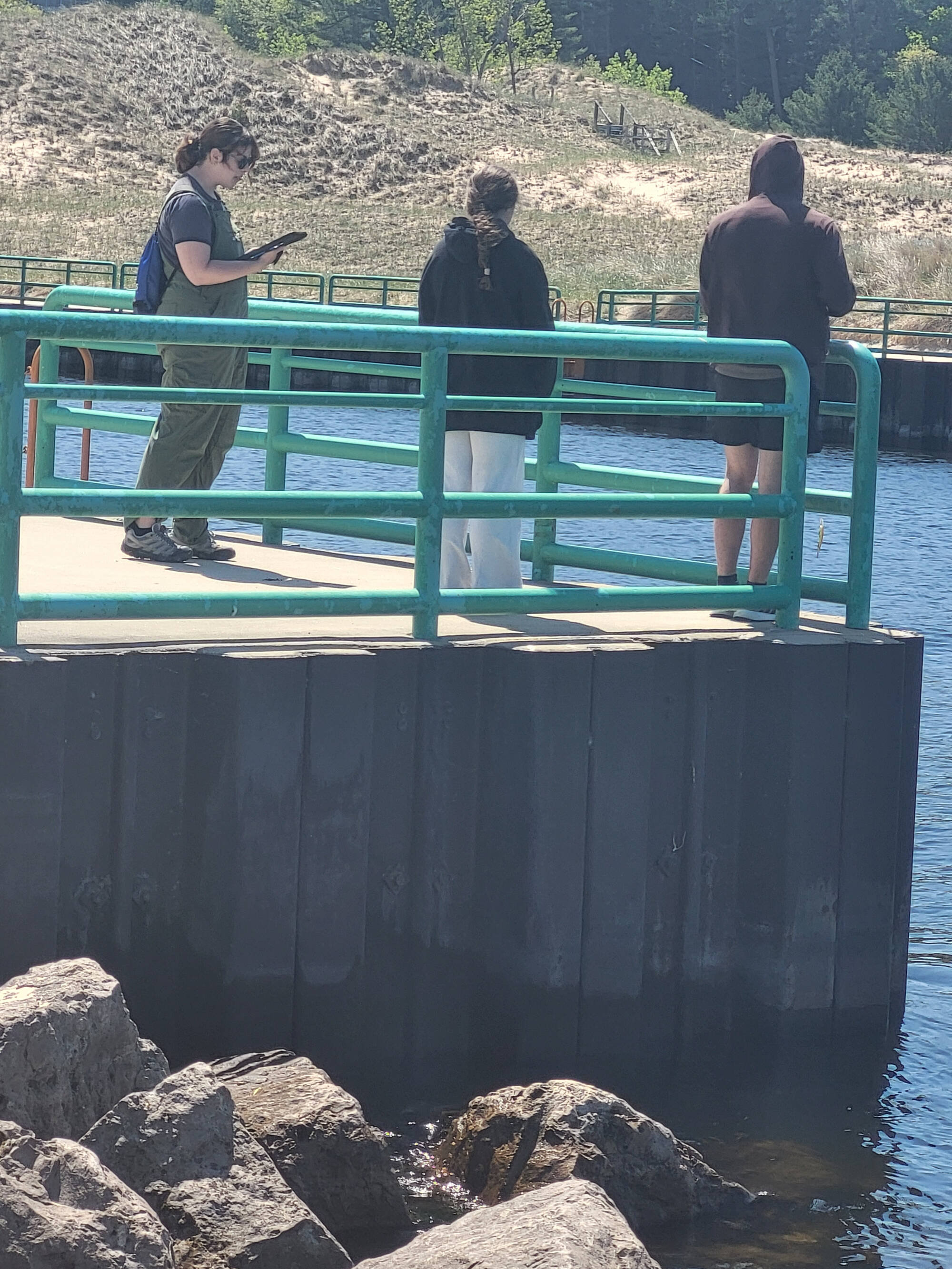 A research assistant interviews anglers along the south channel of Pentwater Lake